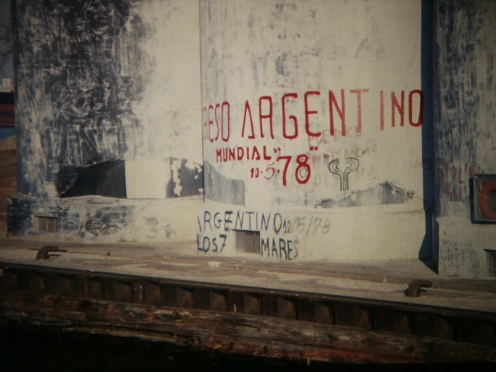 Old industrial structure beside the water bearing red and blue lettering.