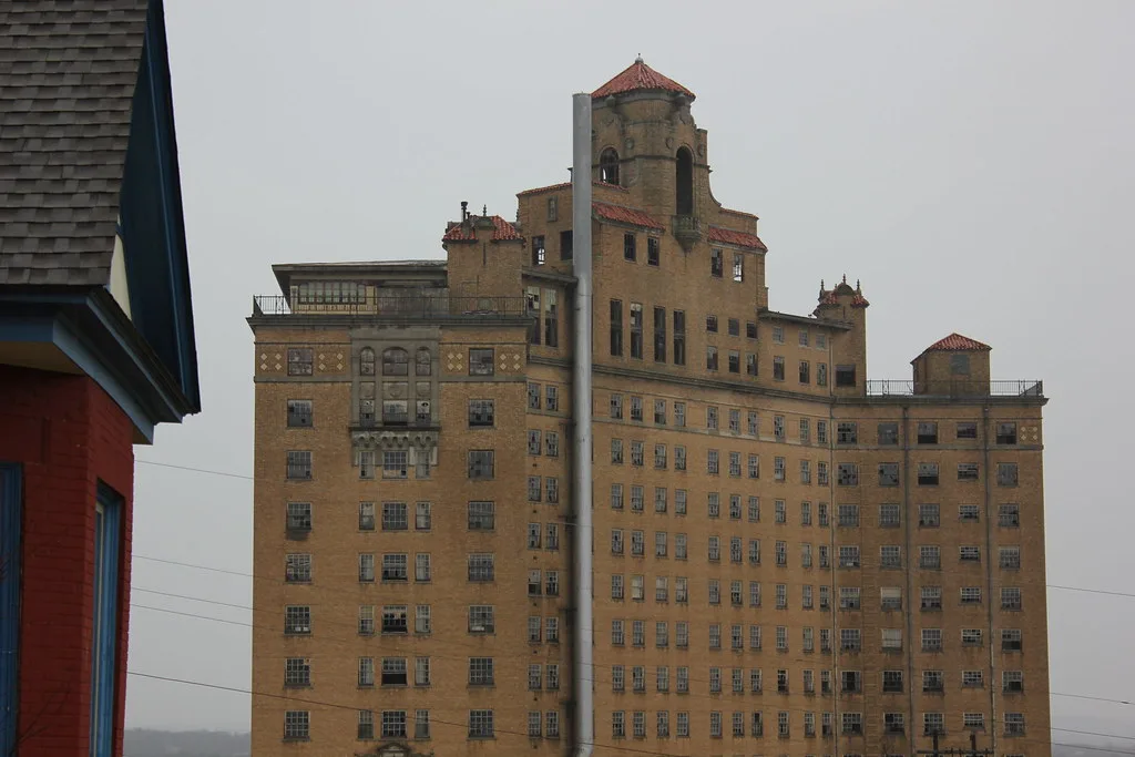 Large old building with broken windows and tiled turrets.