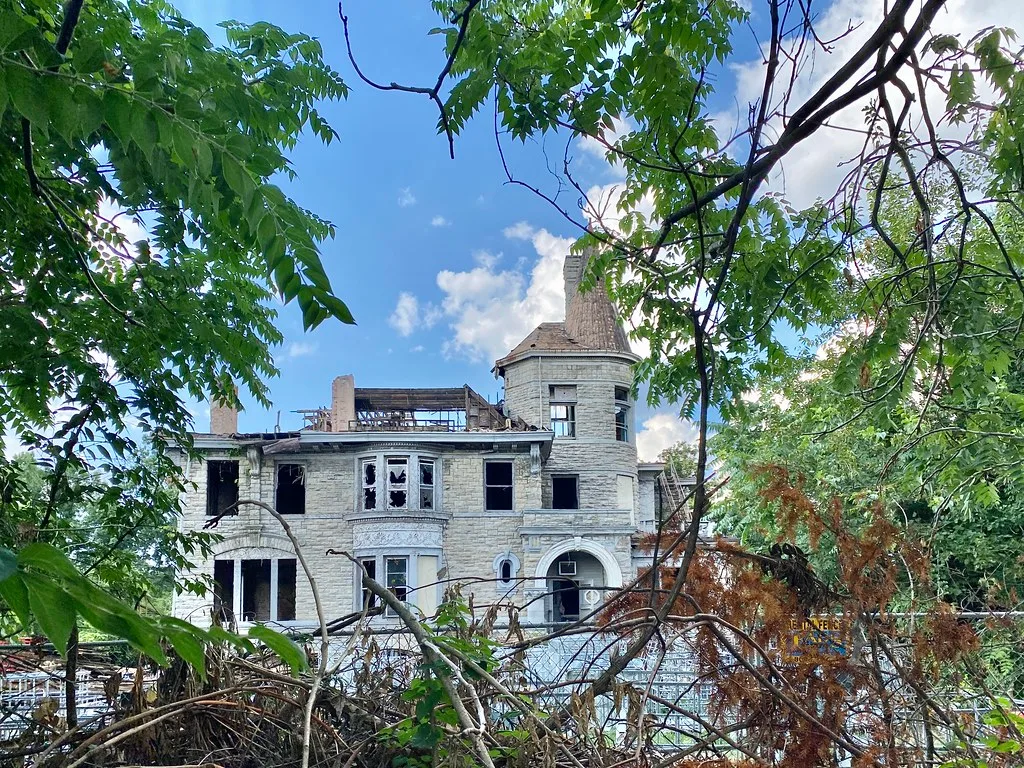 Old turreted house with broken windows and an open roof.
