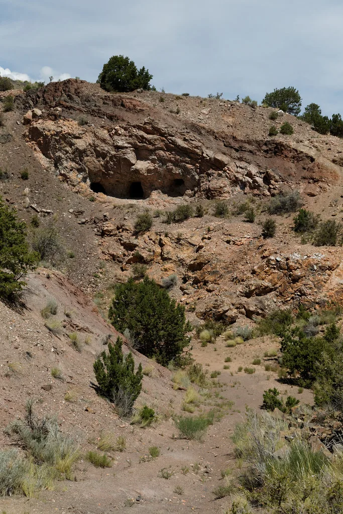 Old openings in a rock face on an arid slope.