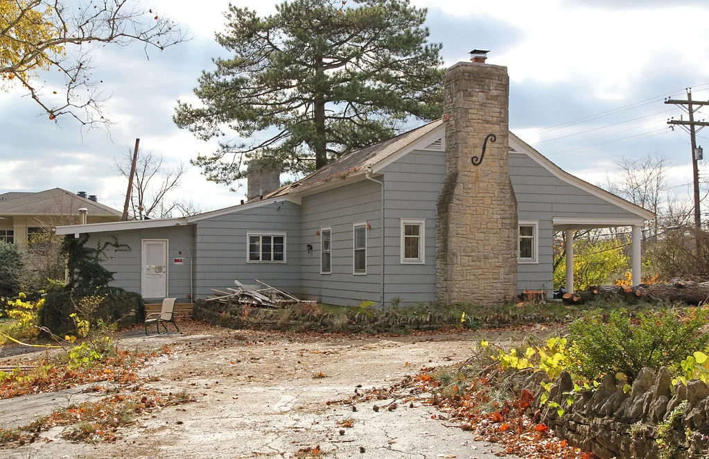 Grey-clad house with a stone chimney in Dublin, Ohio.