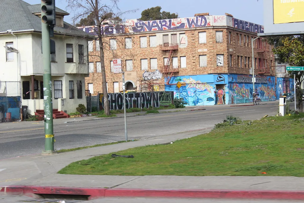 Brick building with boarded windows and facades covered in paintings and graffiti.