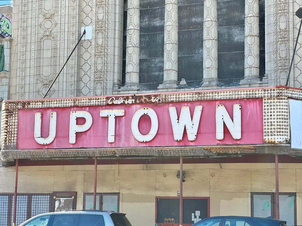 Facade of a closed old theatre with an Uptown sign.