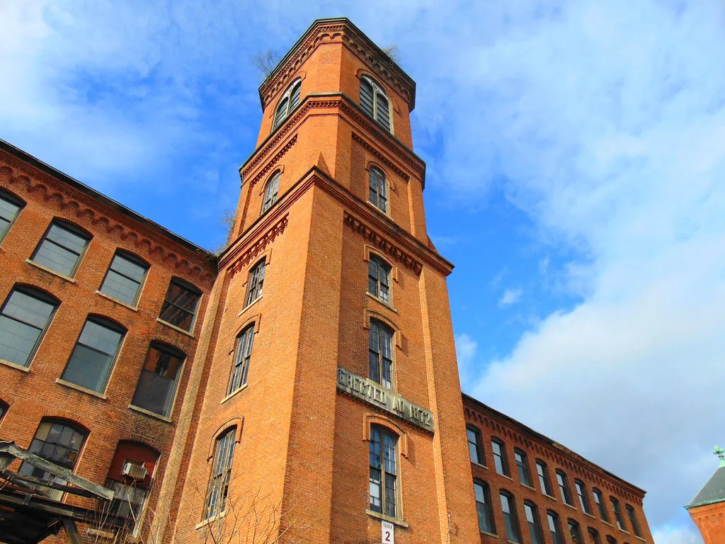 Brick tower of an old industrial building with deteriorated windows.