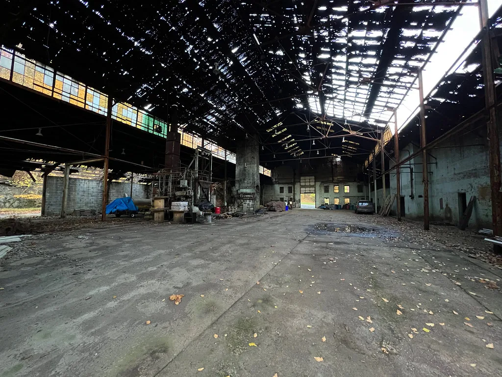 Large industrial hall with a heavily perforated roof.
