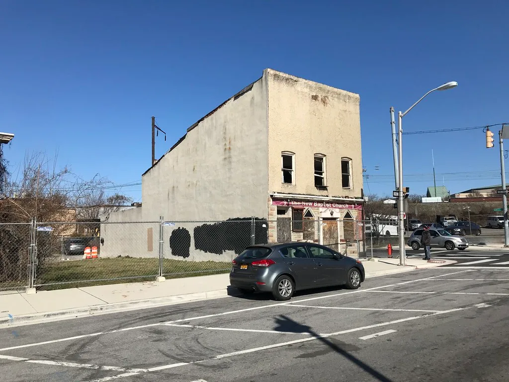 Old religious building with empty windows at an intersection.