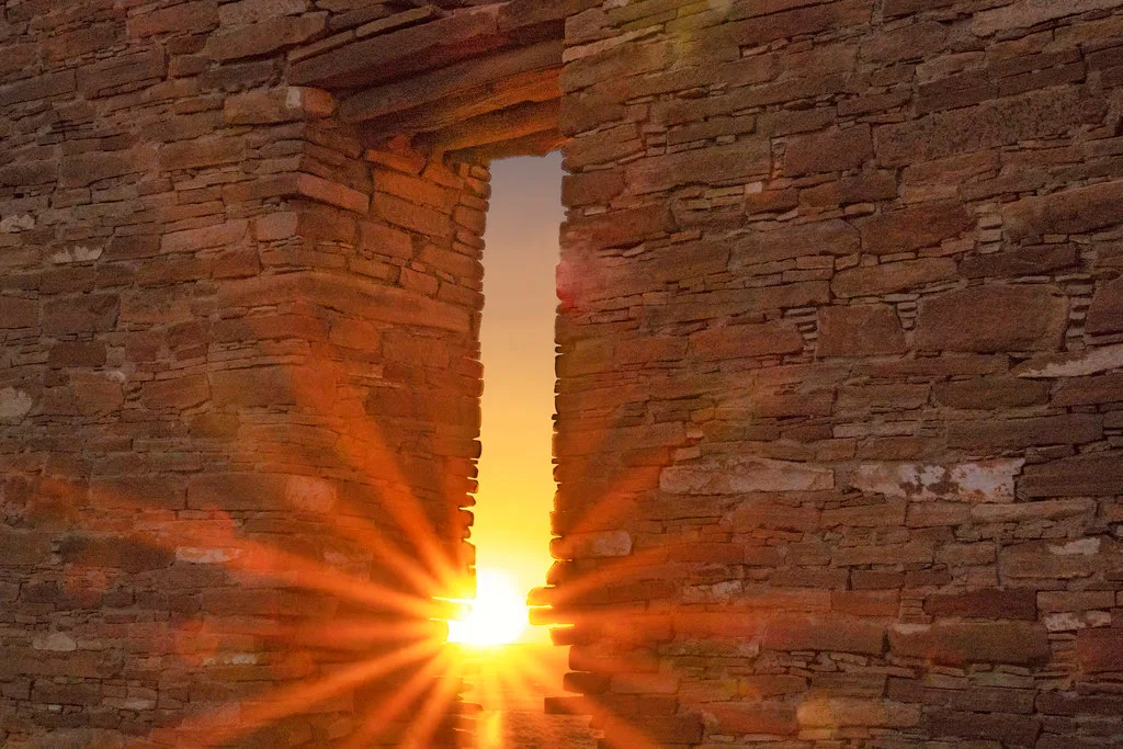 Sunlight through an opening in an old stone wall.