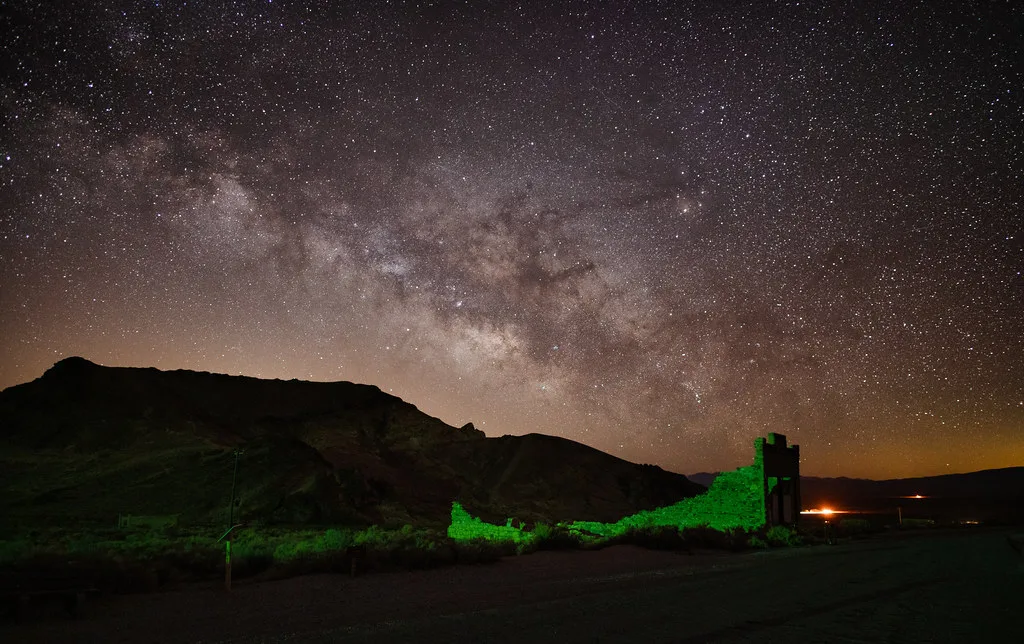 Murs ruinés éclairés en vert sous un ciel étoilé.