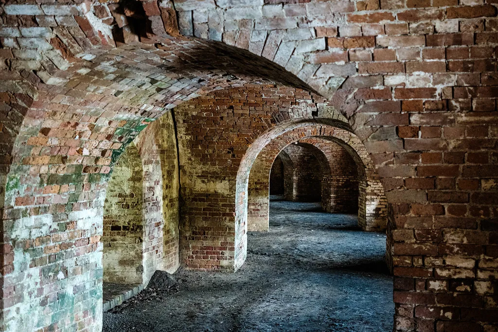 Series of brick arches inside an empty old fort.