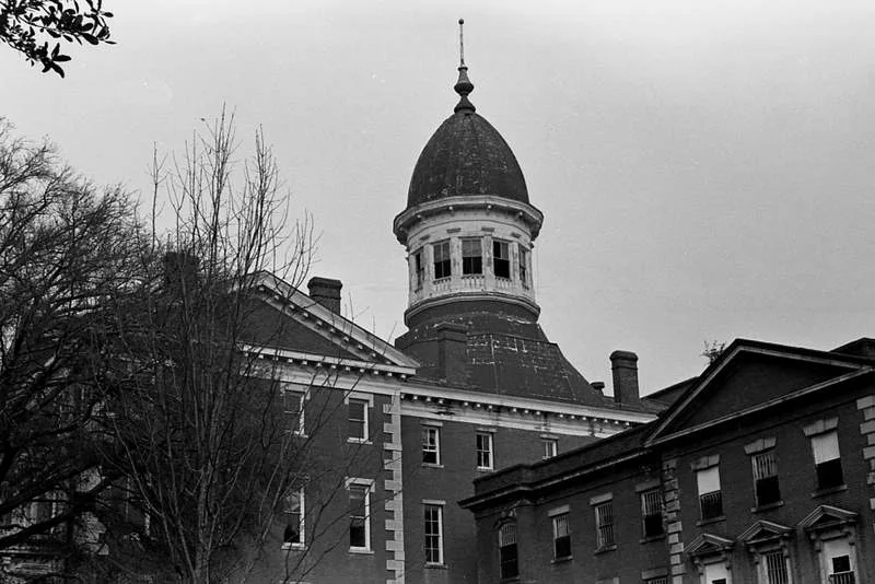 Old domed building with deteriorated windows, in black and white.