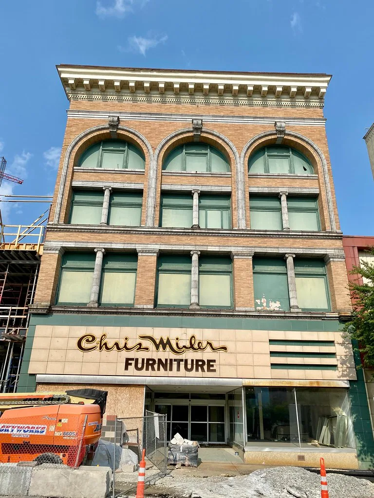 Facade of the McFadden Building in Wheeling with arched windows and a former furniture store.