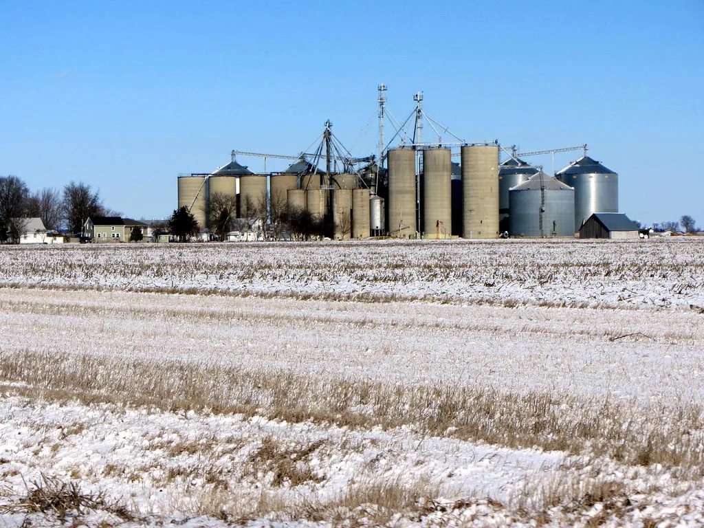 Kasbeer grain silos beyond a lightly snow-covered field.