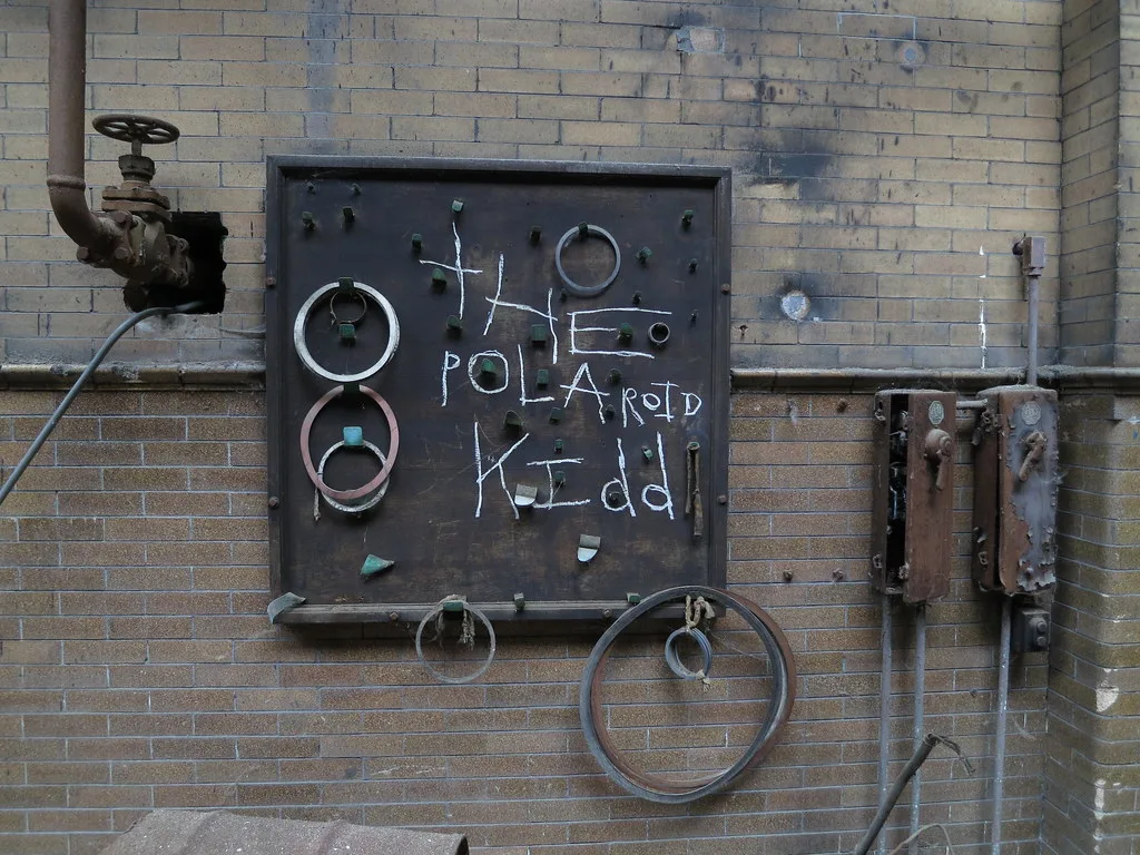 Old industrial panel stripped of its instruments on a brick wall.