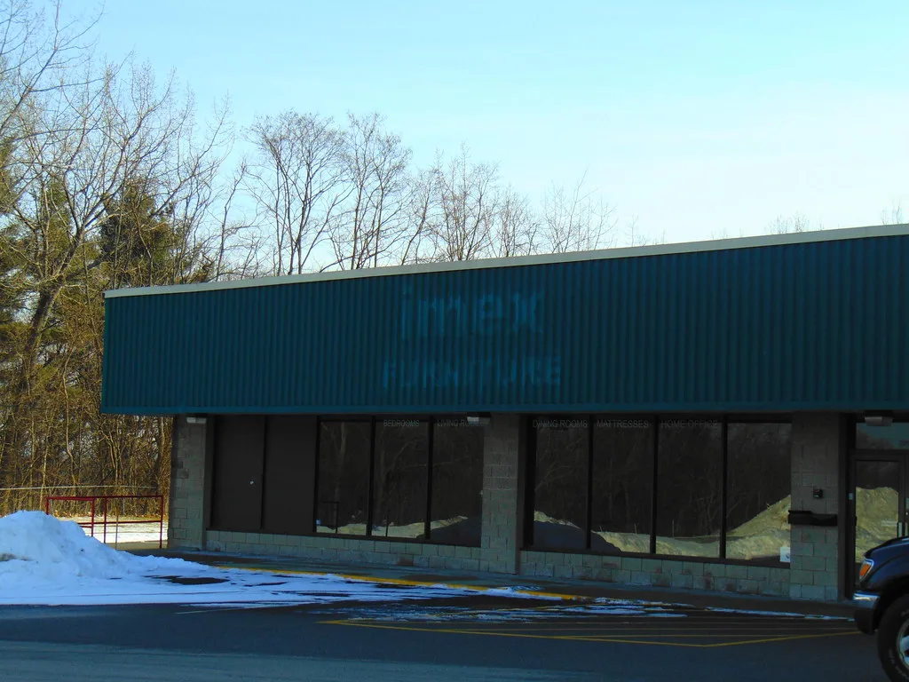 Devanture sombre d’un magasin sous un bandeau bleu sans enseigne.