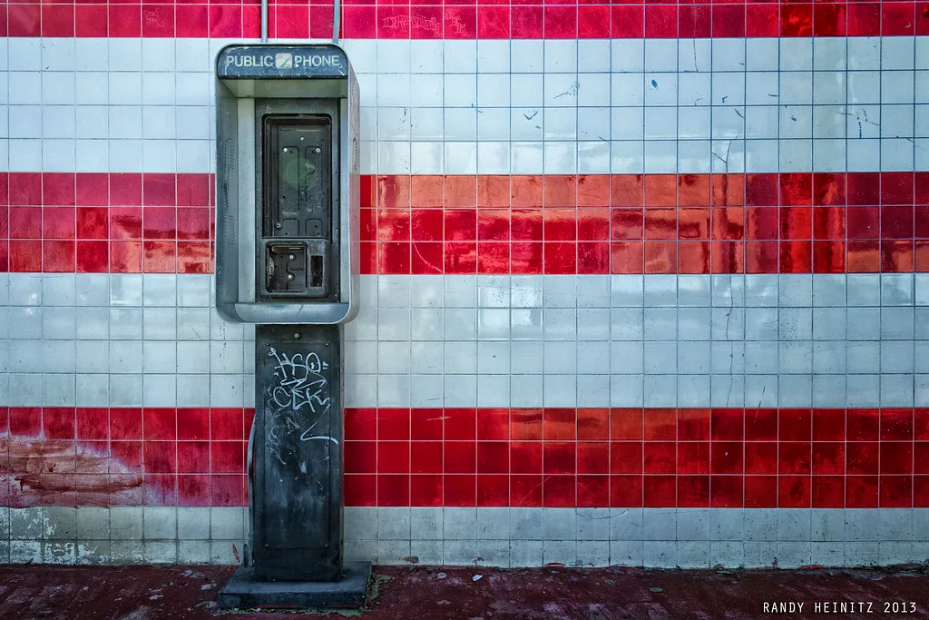 Dismantled former public telephone on a tiled wall in Old Town Indio