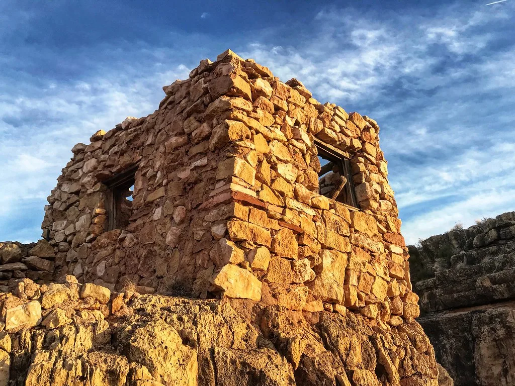 Golden stone ruin on a rocky outcrop.