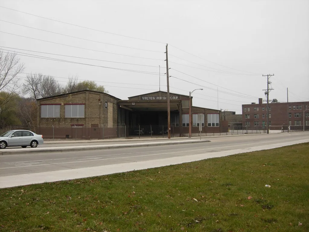 Brick industrial hall with a large central entrance.