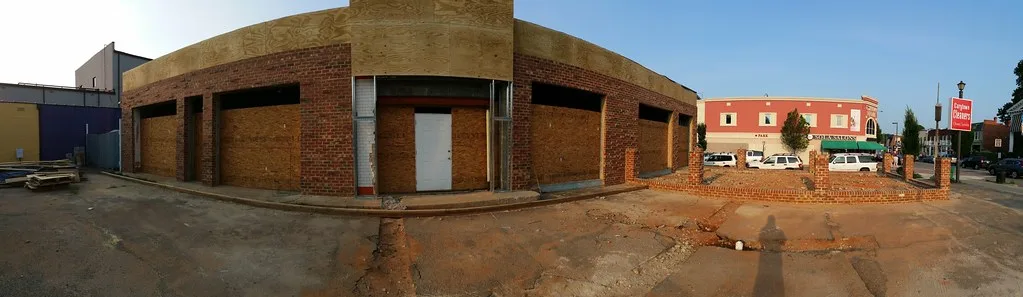 Brick commercial building with panel-covered openings.