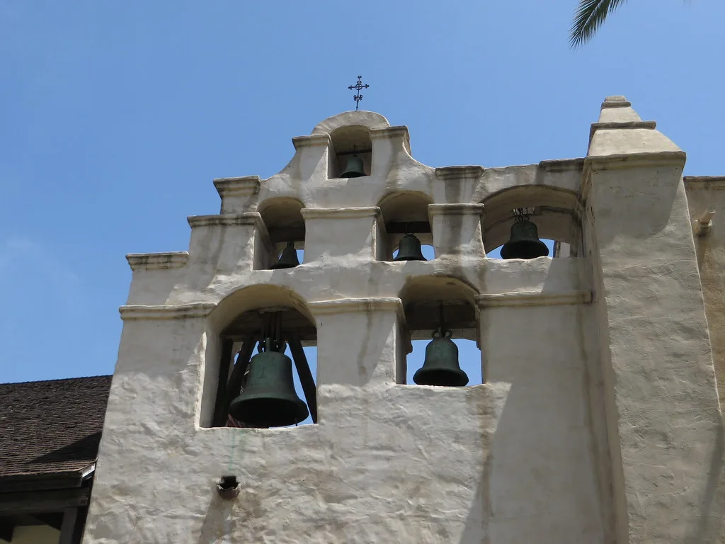 White bell wall with several bells at Mission San Gabriel.