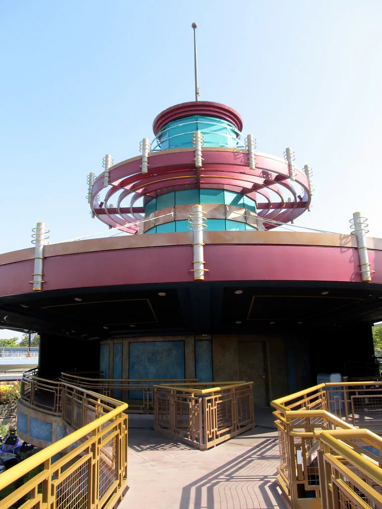 Old circular attraction entrance with yellow railings and pink decoration.