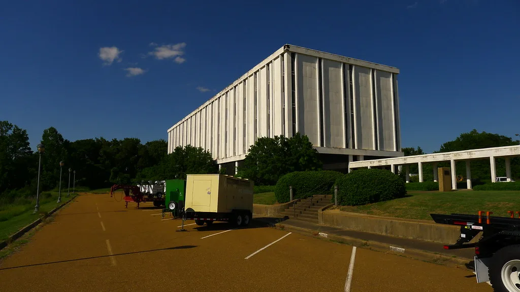 Former MS Chemical building with pale vertical facades above a parking lot.