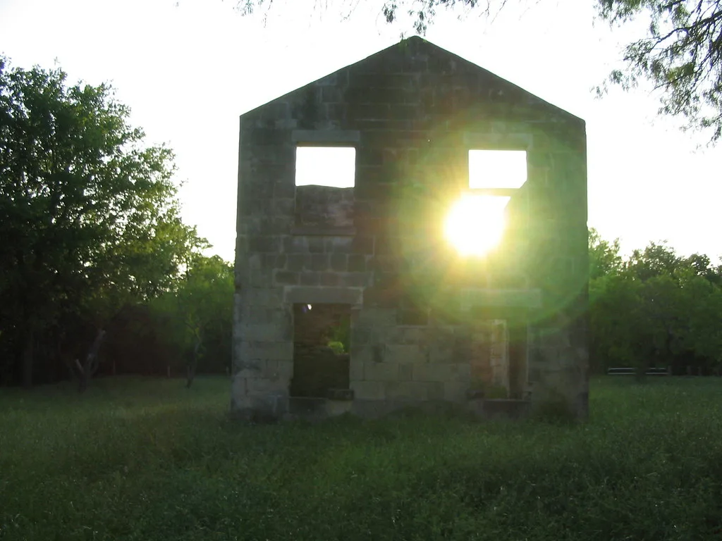 Ruined stone facade with sunlight passing through it.