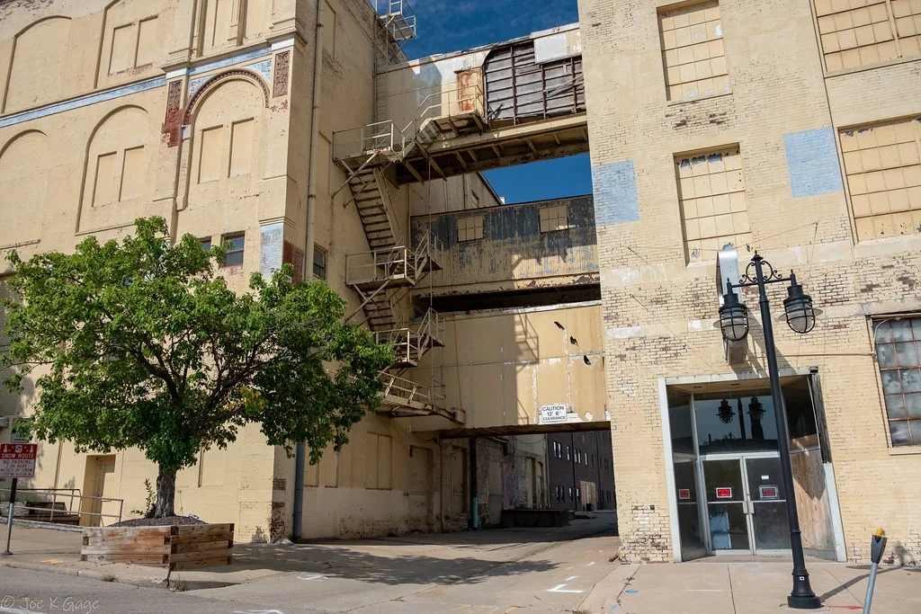 Walkways and stairs between industrial buildings with boarded windows.