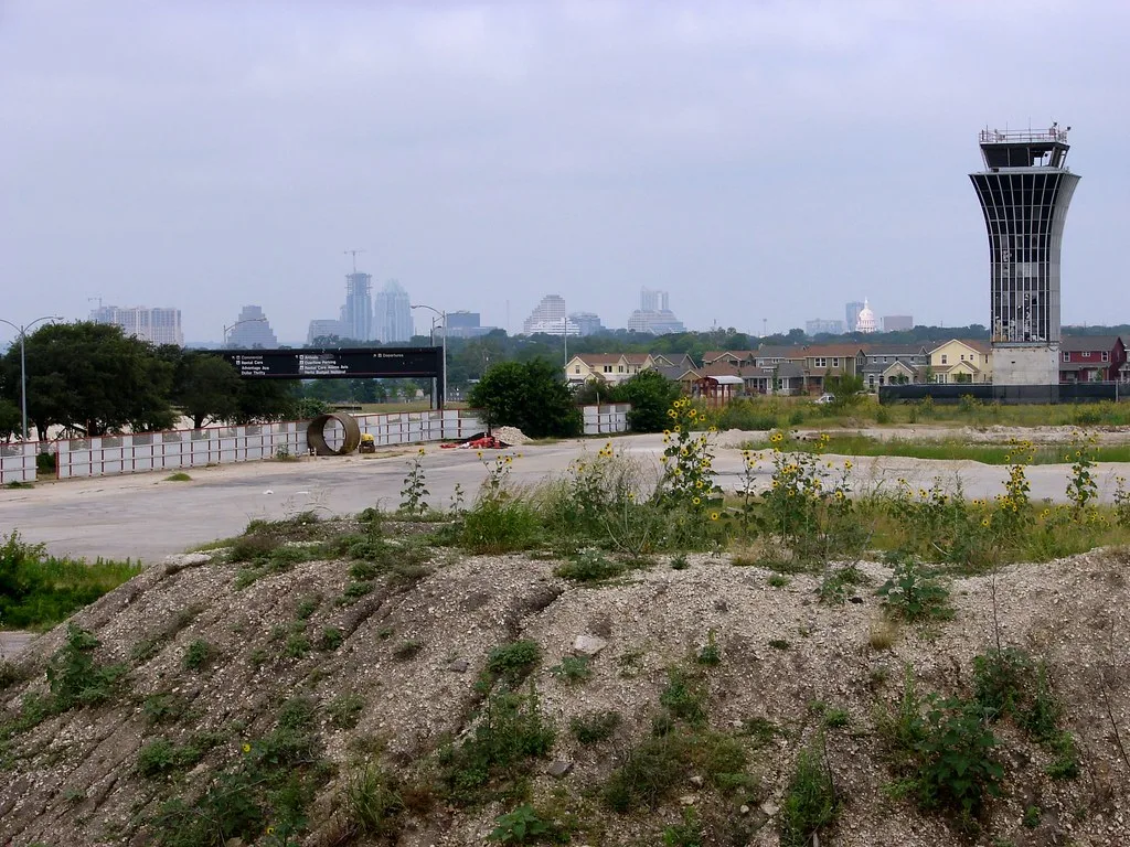 Old control tower beside an overgrown paved area.