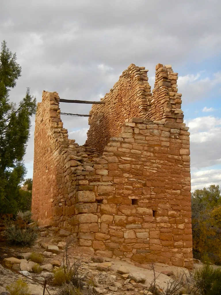 Ruins of an ochre stone building with partly collapsed walls.