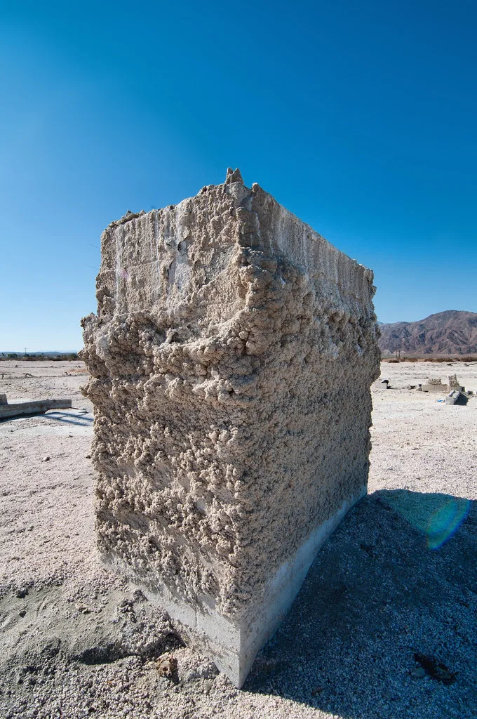 Eroded wall remnant on desert ground.