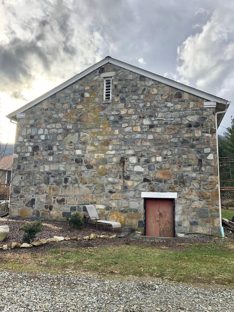Stone gable of the former Stecoah Union School with a red door.