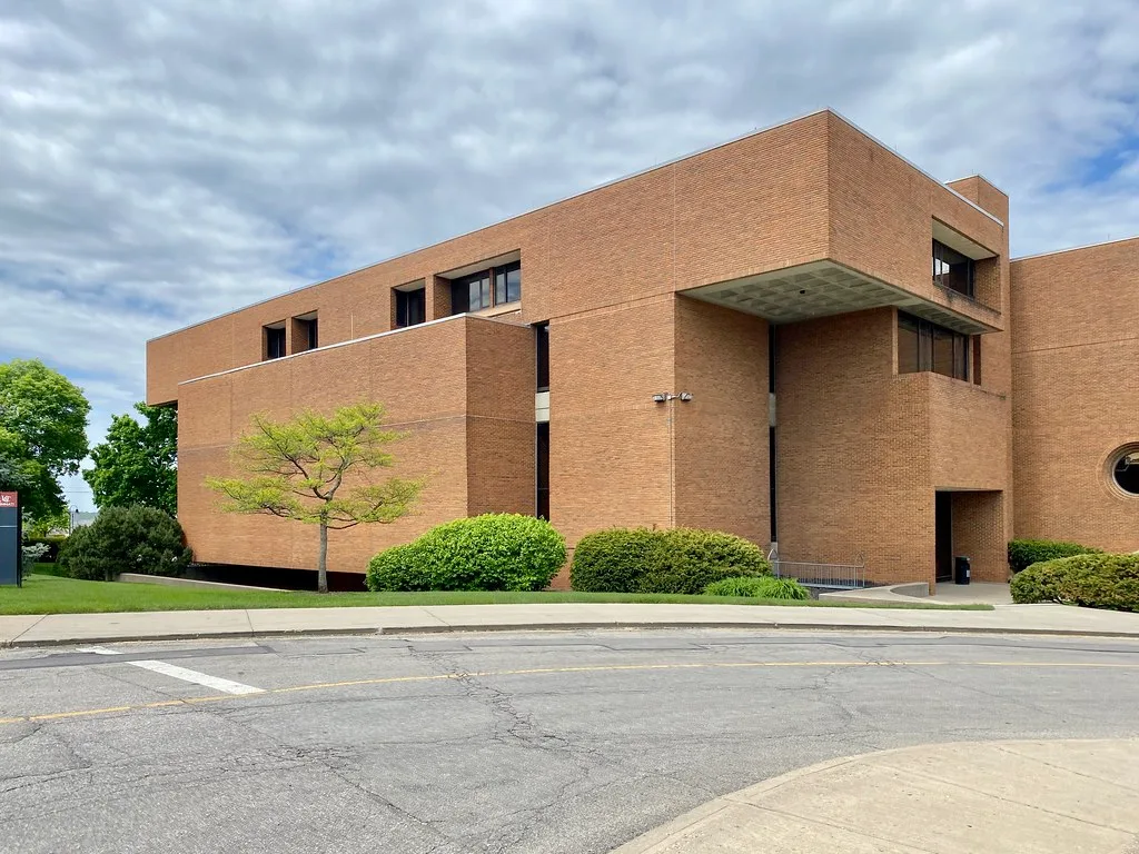 Former Cincinnati law school building with brick volumes and recessed windows.