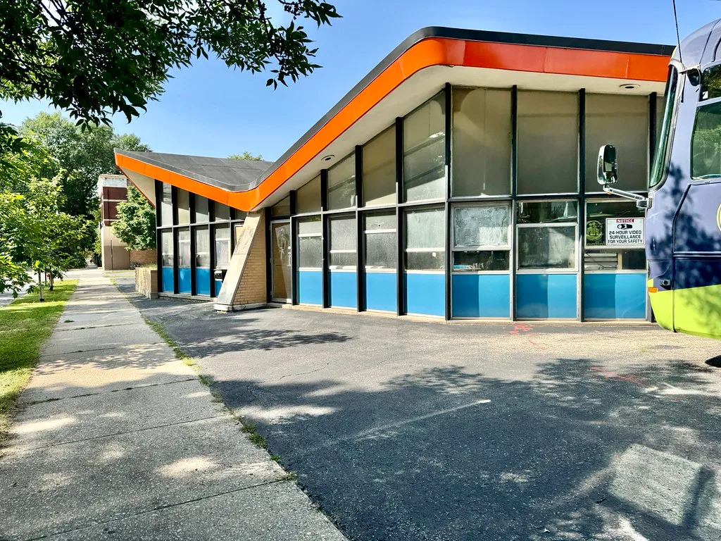 Glazed facade and angular orange roof of Our Lady of Good Counsel School.