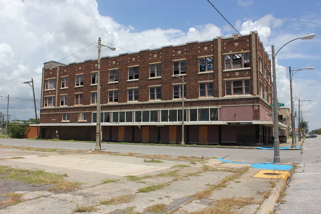 Abandoned brick building with many broken windows.