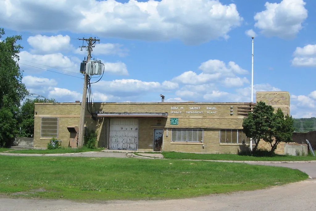 Old yellow-brick water treatment building with weathered doors.