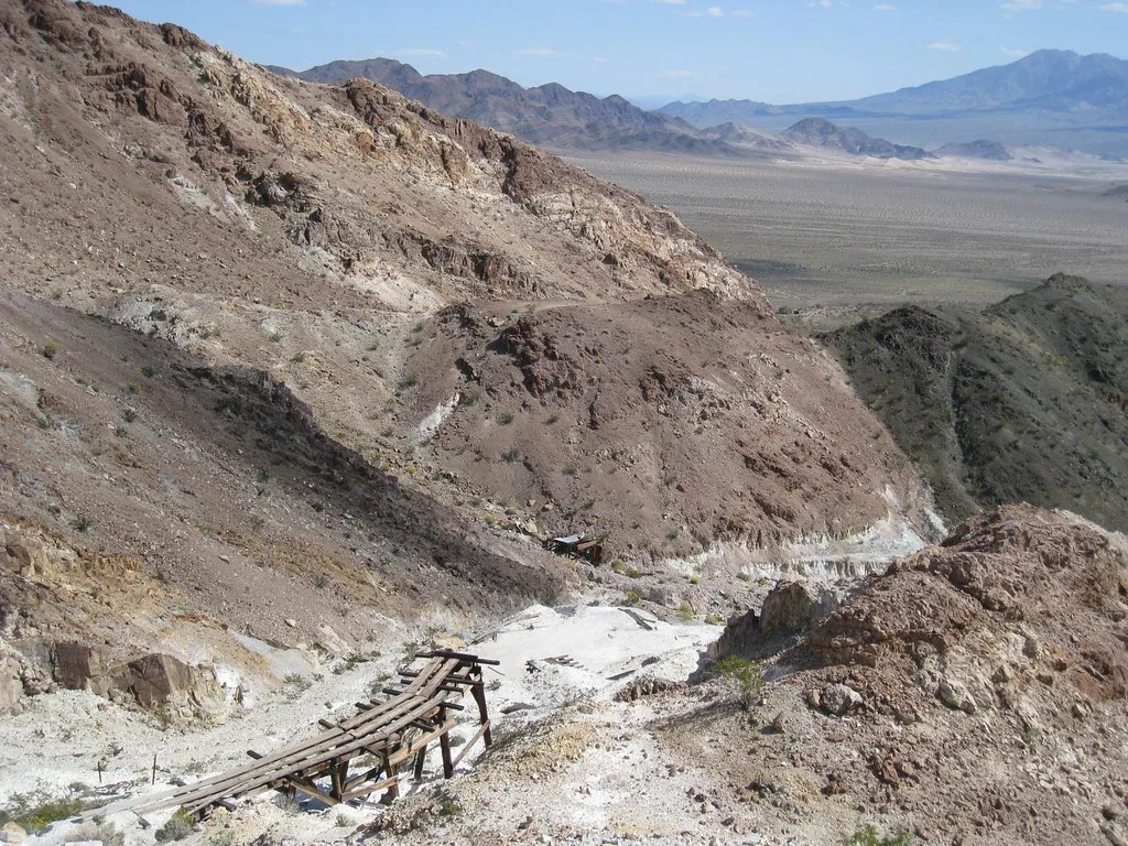 Collapsed old wooden structure in a rocky excavation.