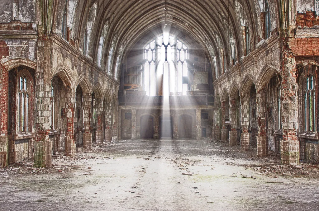 Decaying nave of the former Saint Agnes church lit through a large window.