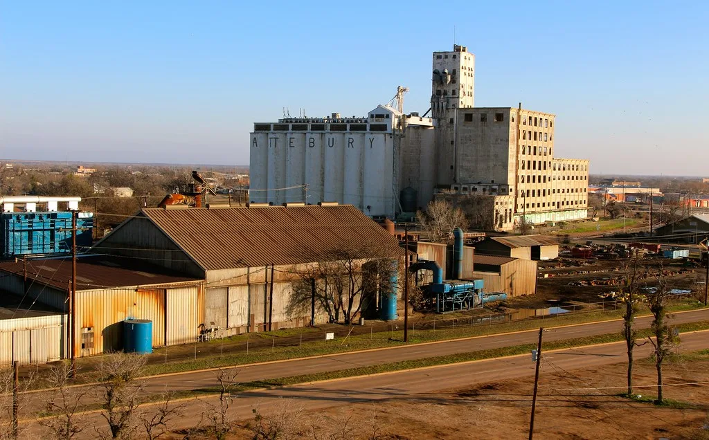 Old industrial building and silos behind sheds.