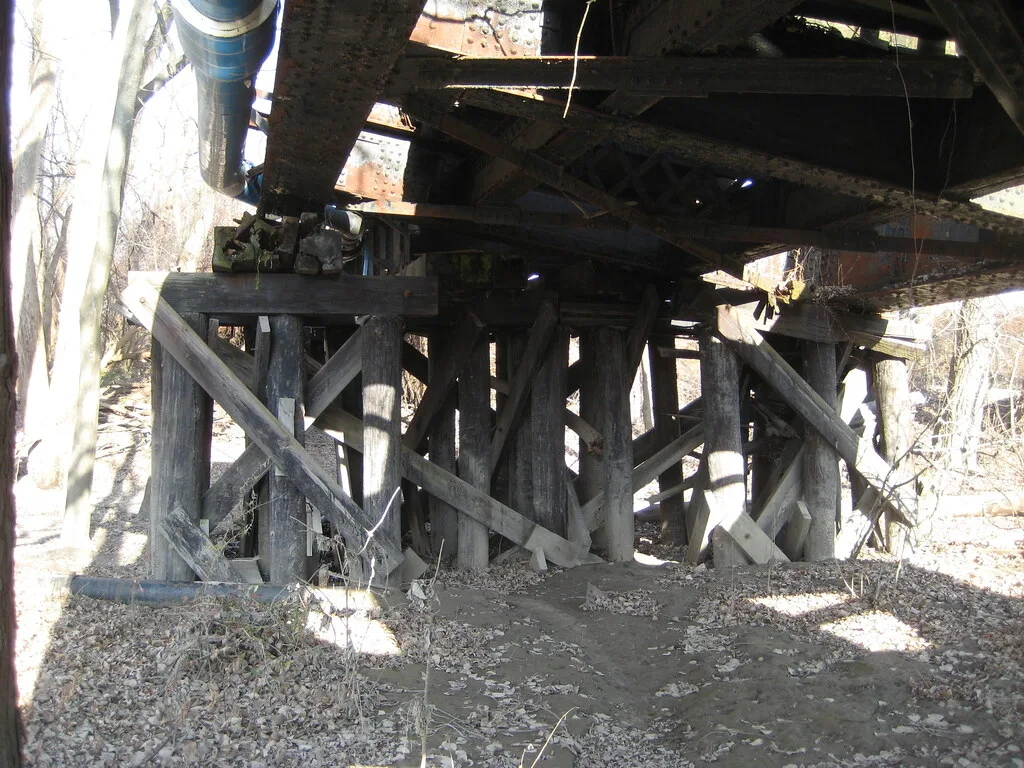 Old timber supports beneath a rusty metal structure.
