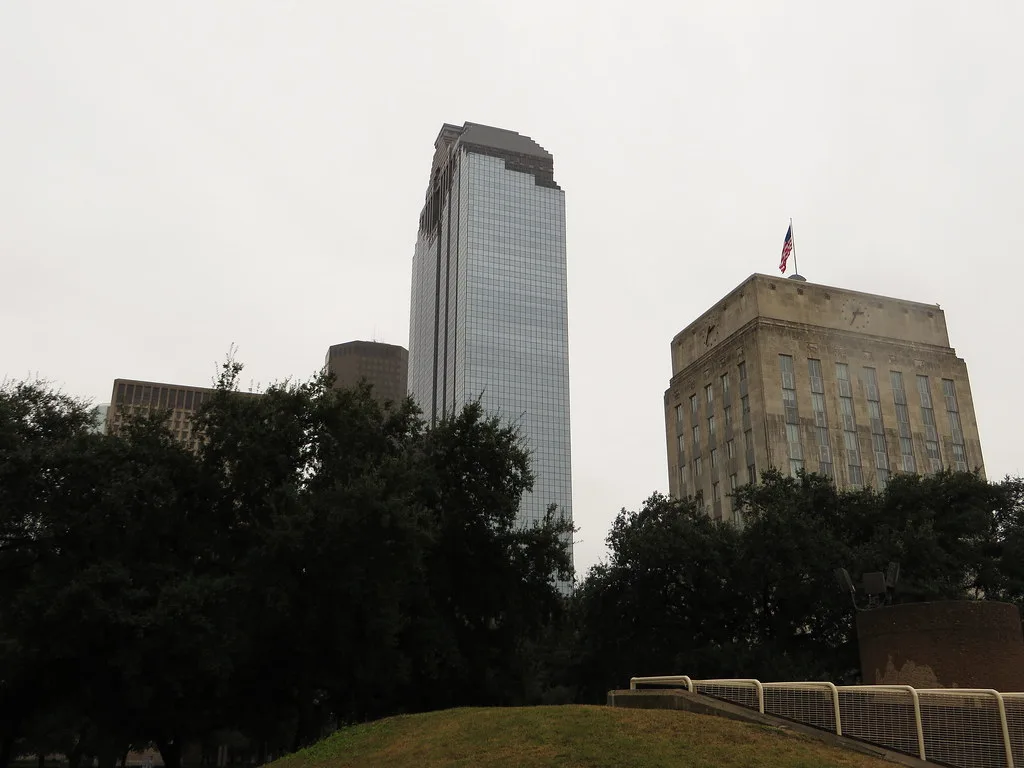 Heritage Plaza tower in Houston above trees and neighboring buildings.