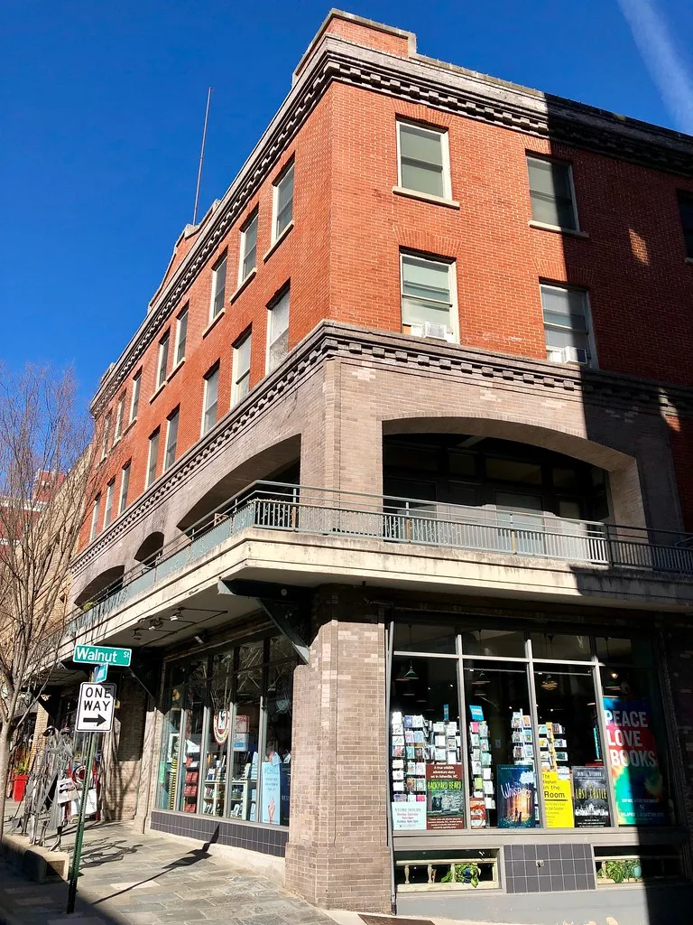Former Asheville Hotel on Haywood Street with a balcony above the shops.