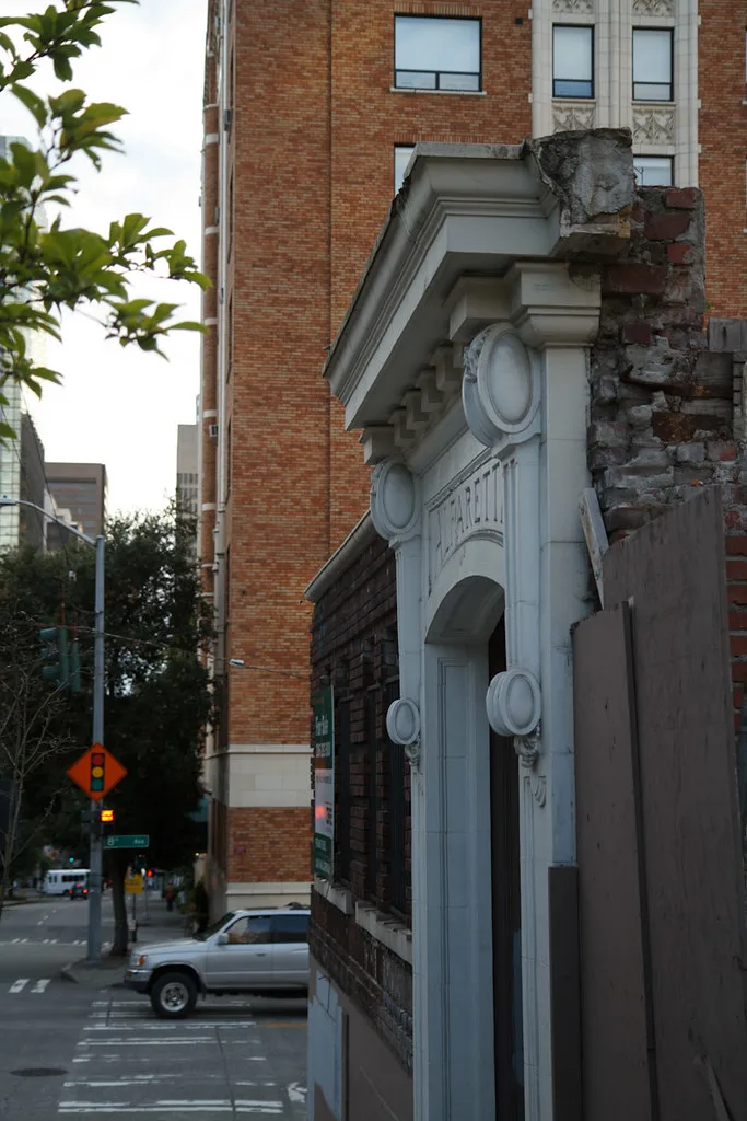 Vestige de portail orné dans une façade partiellement démolie.