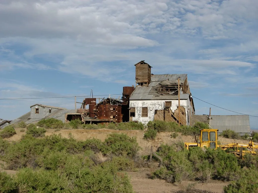 Old wood and metal industrial building with a collapsed roof.