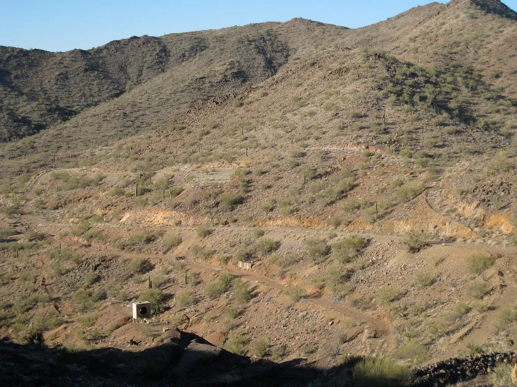 Small concrete remnants and tracks on an arid rocky hillside.