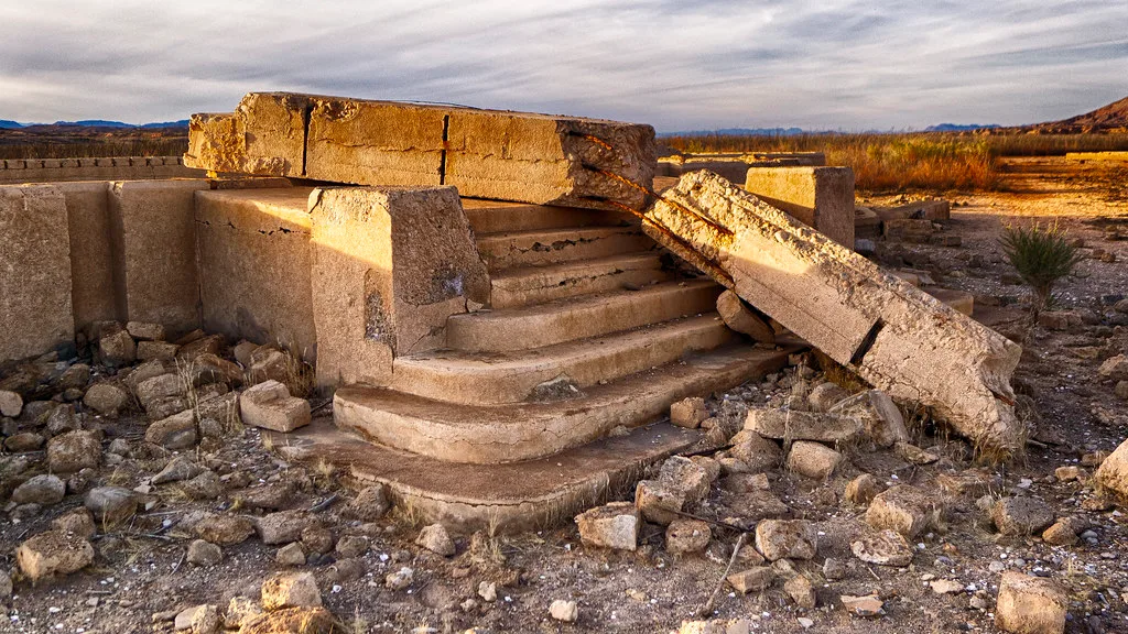 Concrete staircase remaining from a building, surrounded by blocks and rubble.