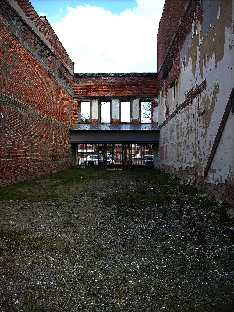 Brick walls and empty windows of a roofless building.