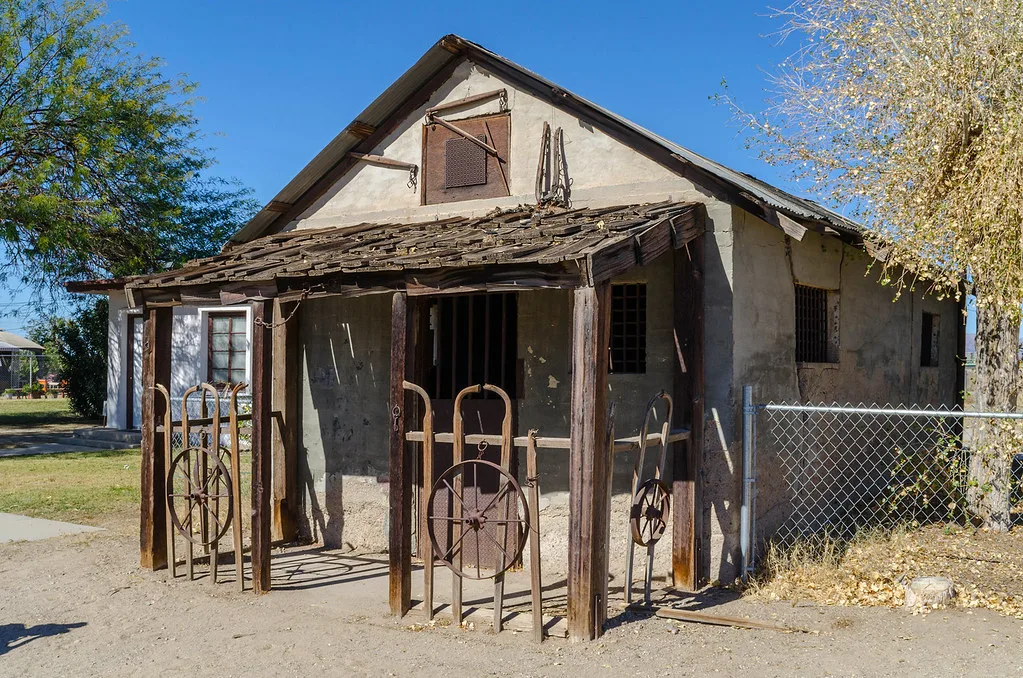 Small former jail with a decaying wooden porch.