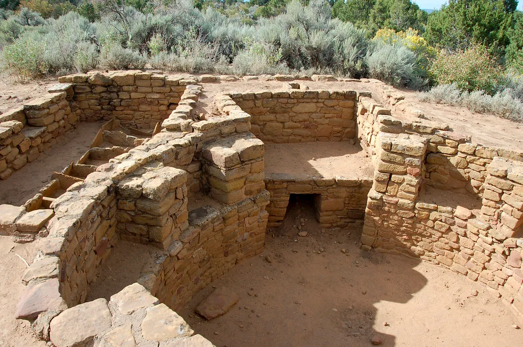 Vestiges de pièces circulaires et de murs en pierre ocre.