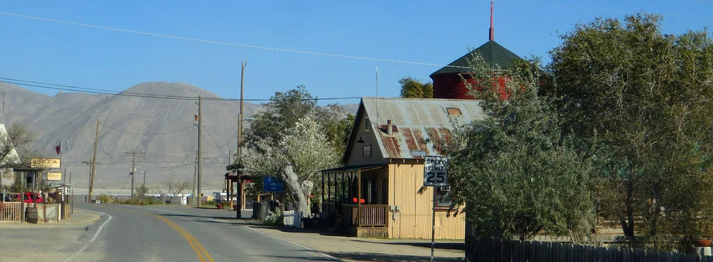 Buildings in Gerlach, Nevada, along a road with dry mountains behind them.