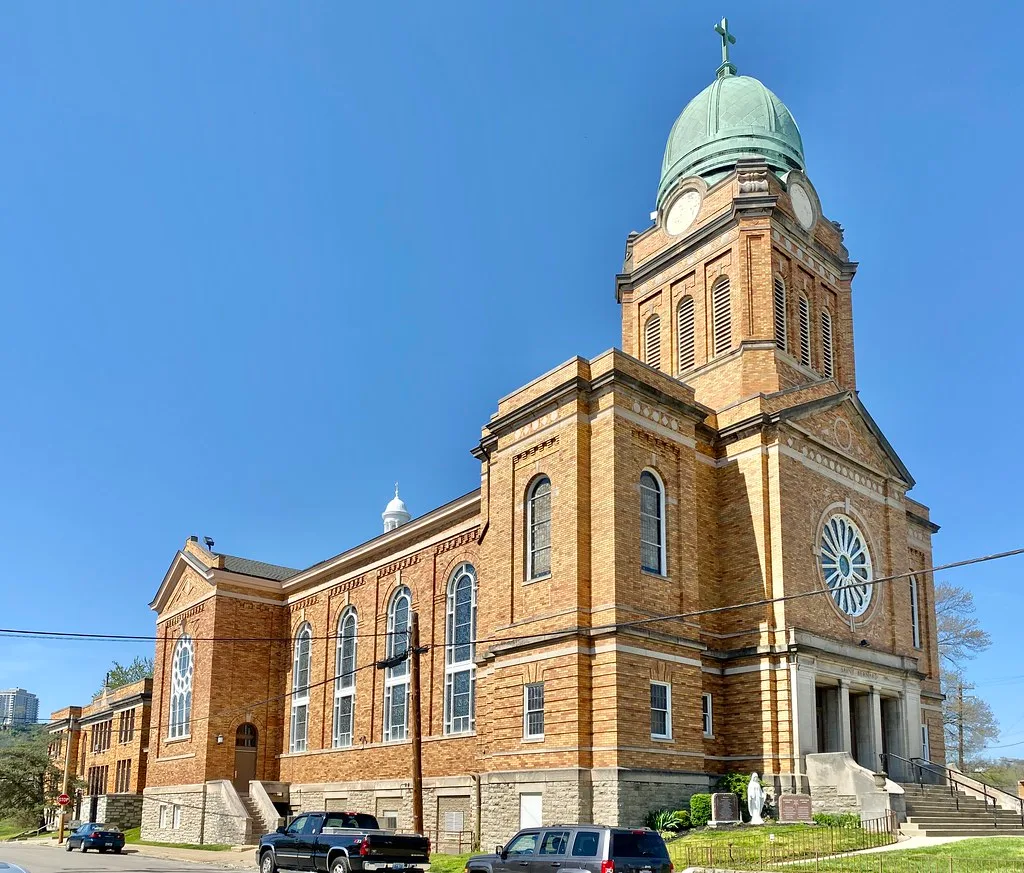 Saint Bernard Church in Dayton with a brick facade and a green-domed tower.